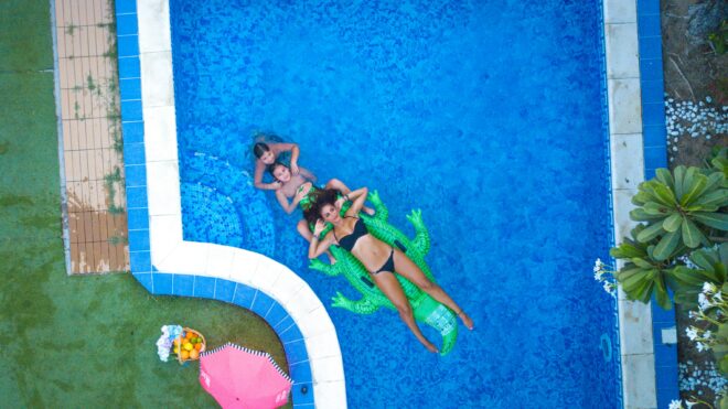 woman and kids in a pool on an alligator floatie