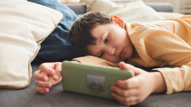 Bored Little Boy Using Smartphone