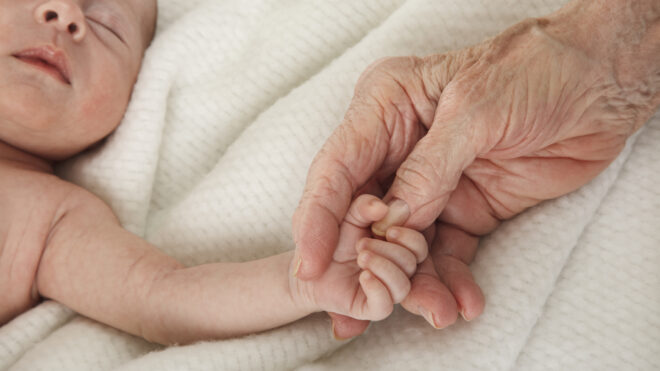sleeping baby holding great grandmother's hand
