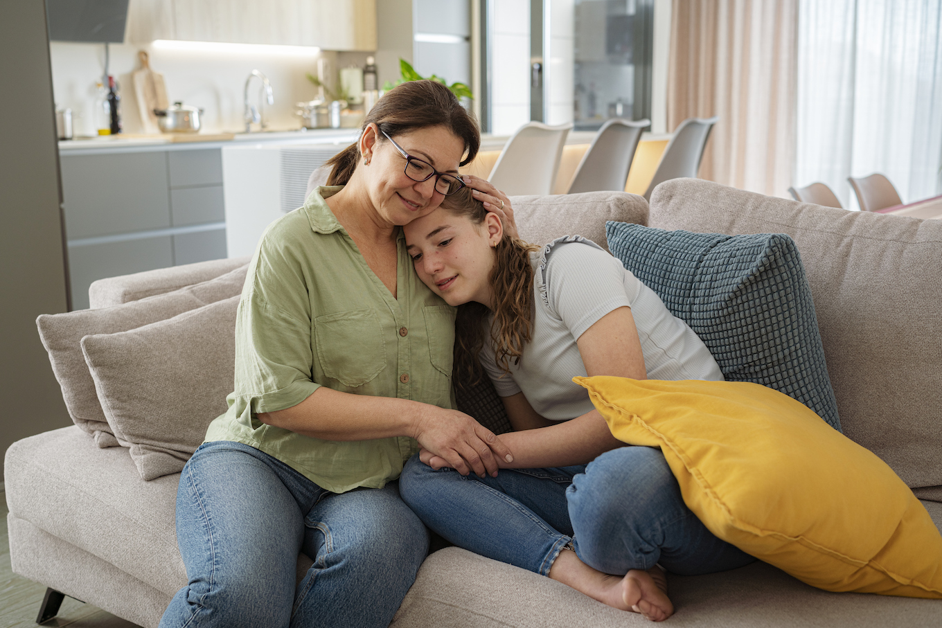 Mom hugging teen daughter