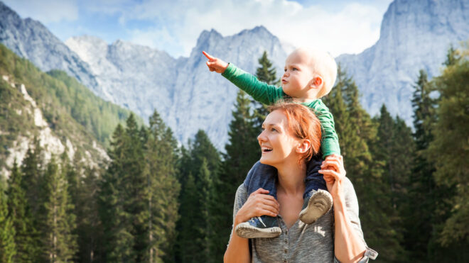 Happy mother and her child looking forward and pointing to sky. Family on trekking day in the mountains. Mangart, Julian Alps, National Park, Slovenia, Europe. Travel, Explore, Family, Future Concept