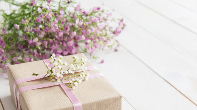 Mother's day, white wooden table with flowers and a present