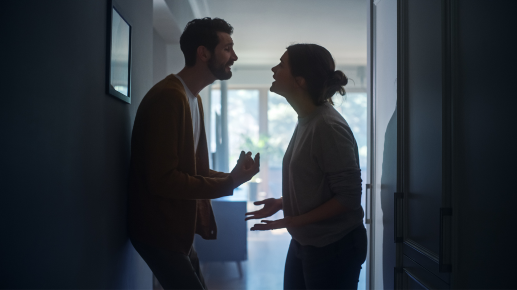 young couple slightly shadowed during an argument in a hallway