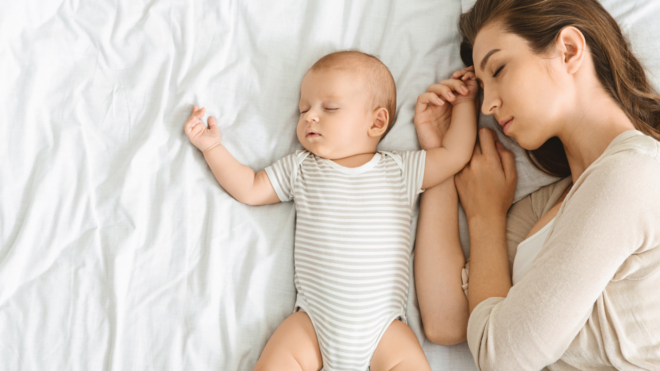 mom sleeping on her side in bed with baby sleeping next to her on its back